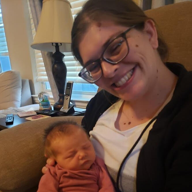 picture of me and my newborn daughter when we came home from the hospital. I am sitting in a recliner holding my daughter and smiling