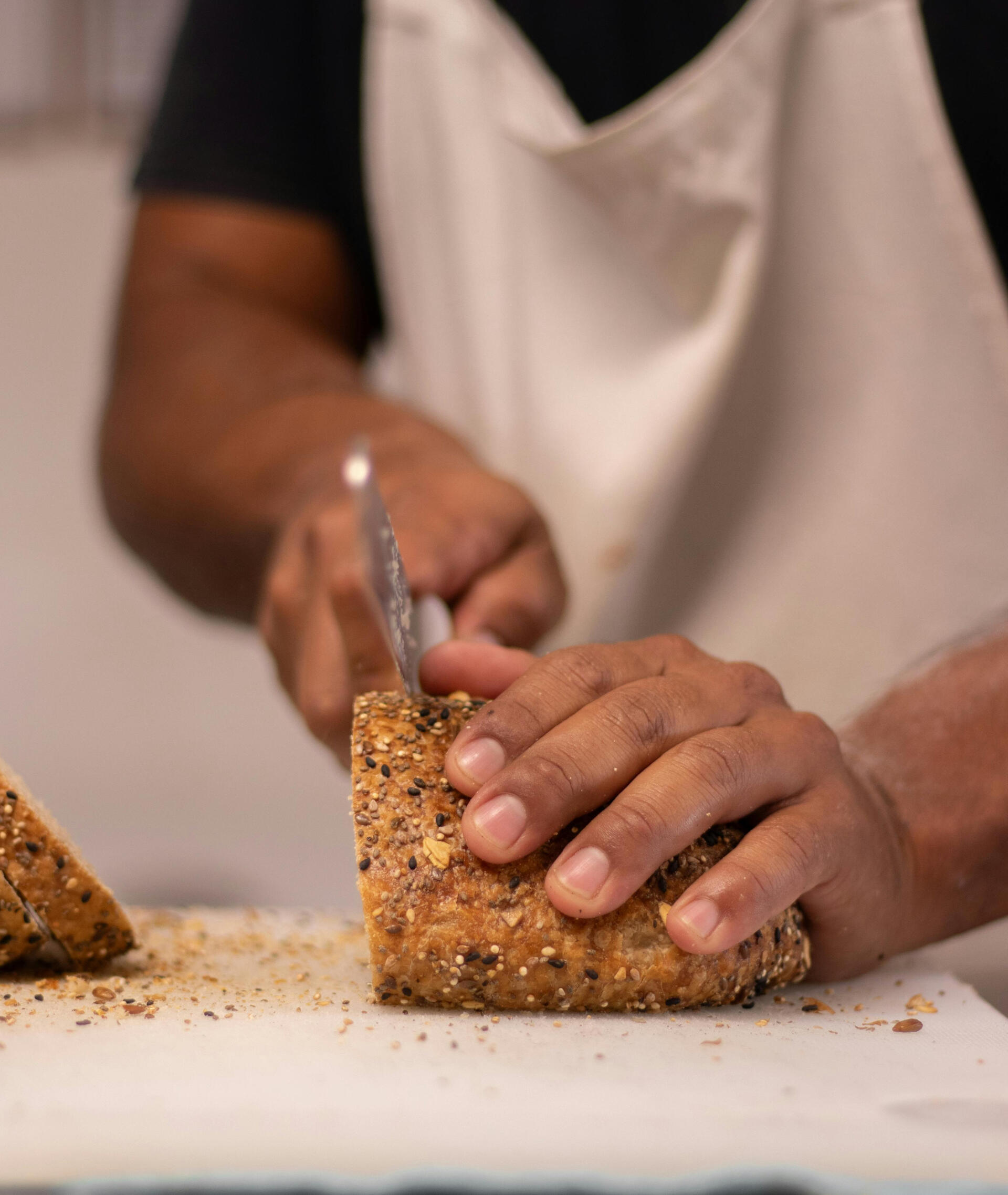 adult cutting a piece of bread