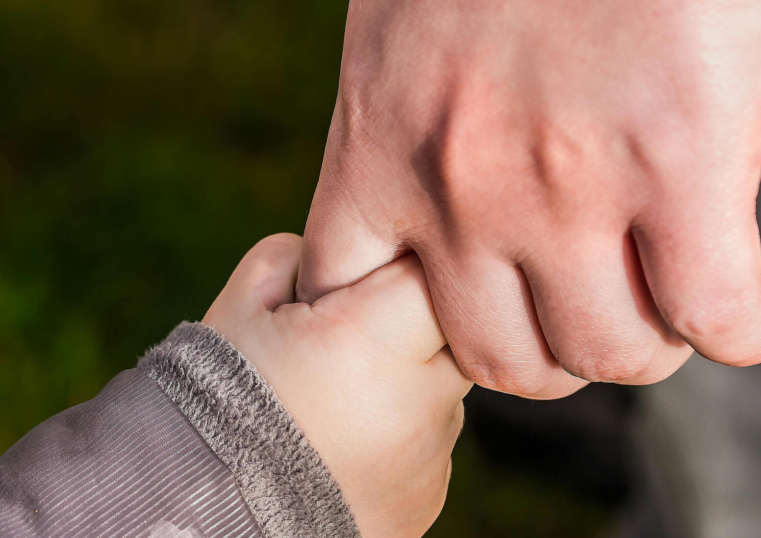 Child's hand gripping an adults finger